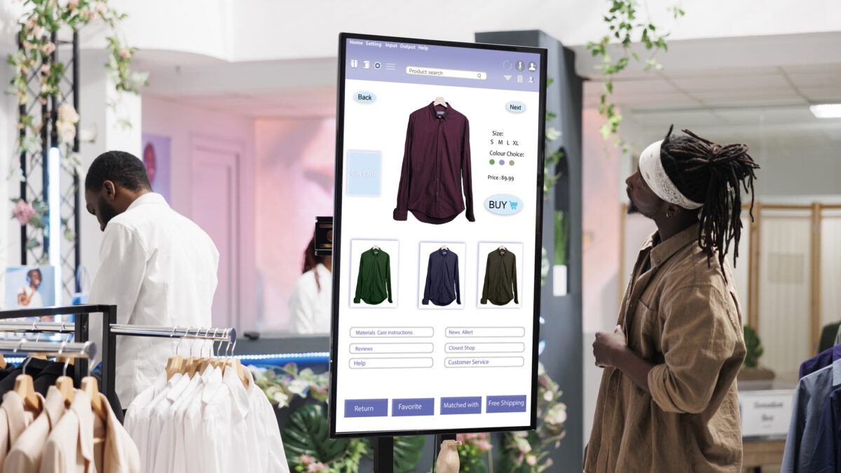 A man viewing cloud based digital signage displays inside a modern shopping store