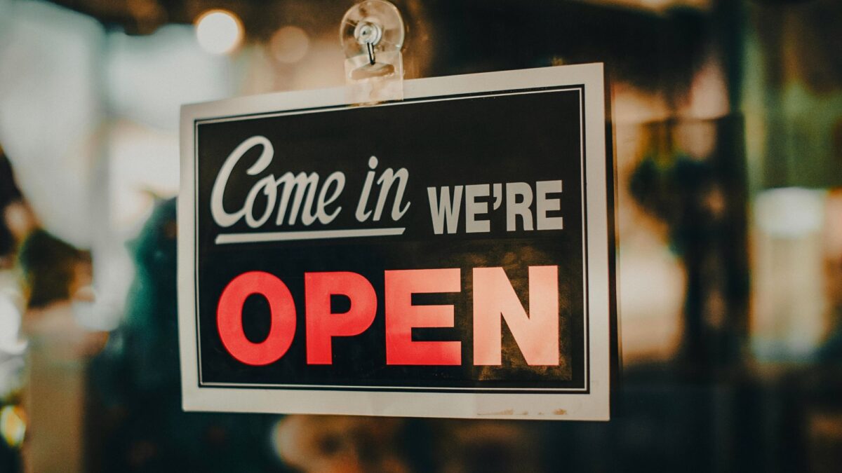 An open sign on a store’s door highlights how automotive local SEO and Google Maps help bring foot traffic back