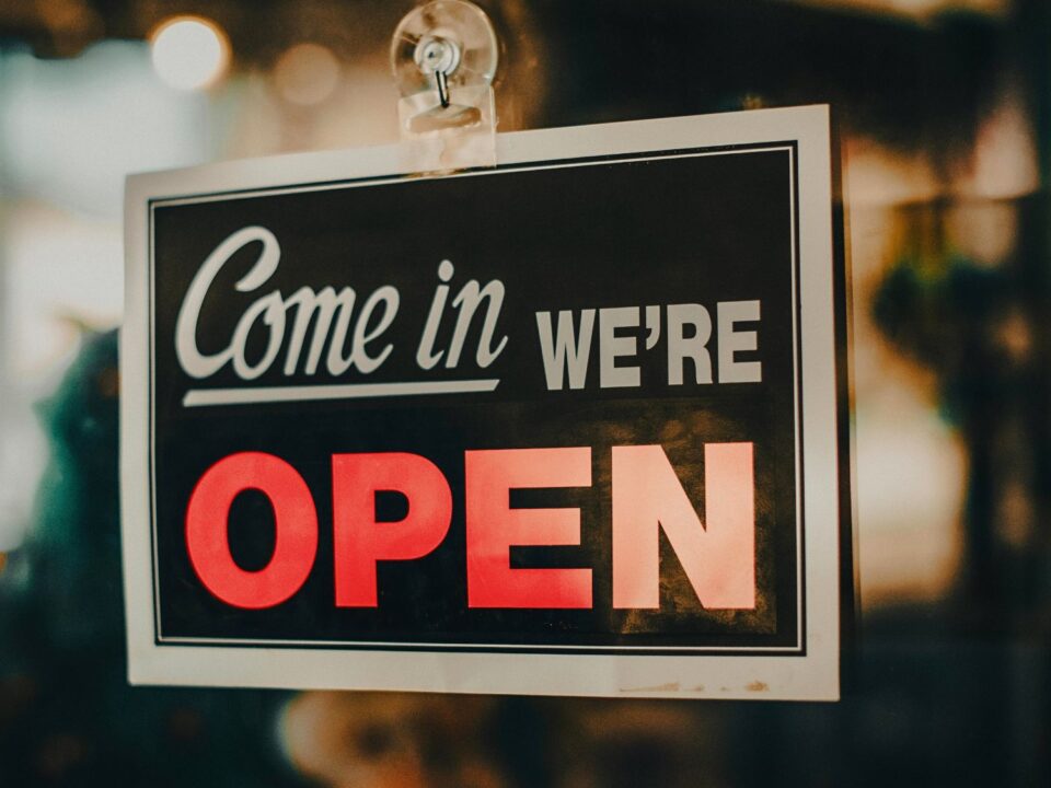 An open sign on a store’s door highlights how automotive local SEO and Google Maps help bring foot traffic back